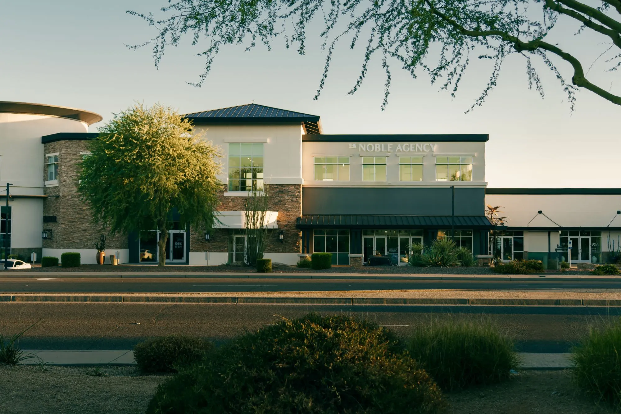 The Noble Agency's Scottsdale office, a two-story building with the company name above the windows, at golden hour