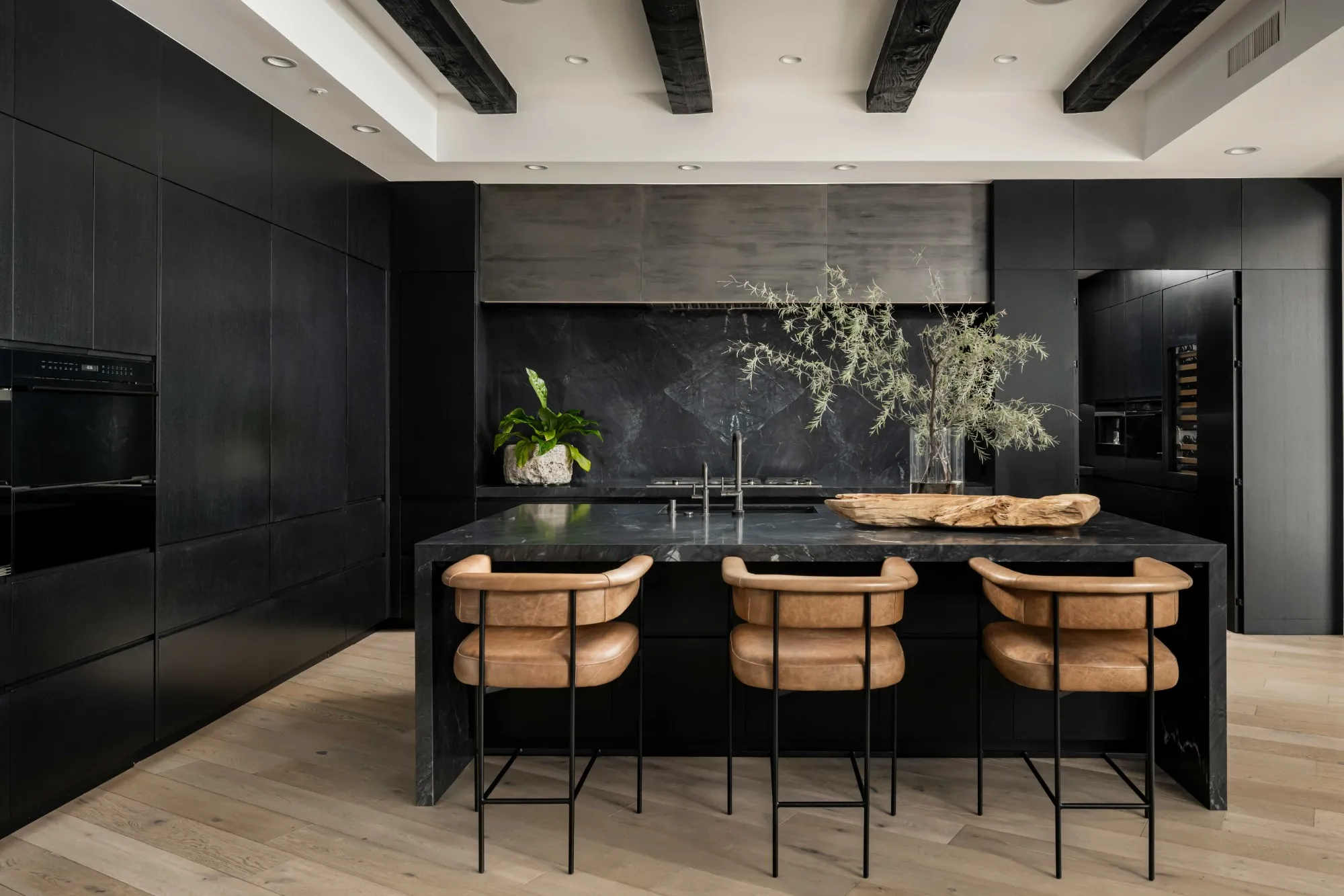 Dark stone kitchen island with leather counter stools